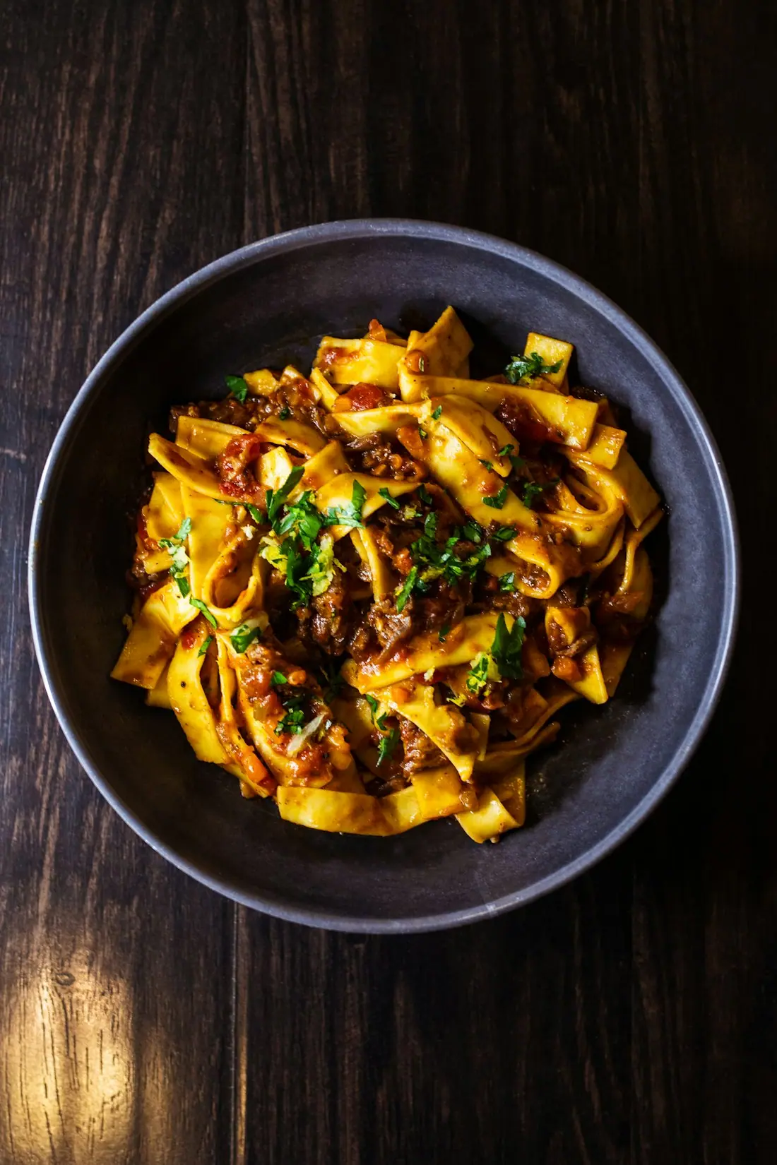 Pasta with ragù in a dark bowl